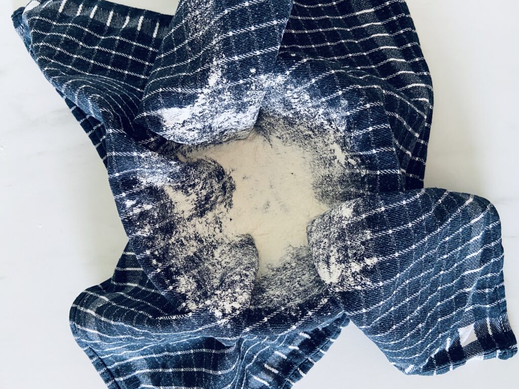 Floured tea towel inside of a bowl for the dough to rest in. 